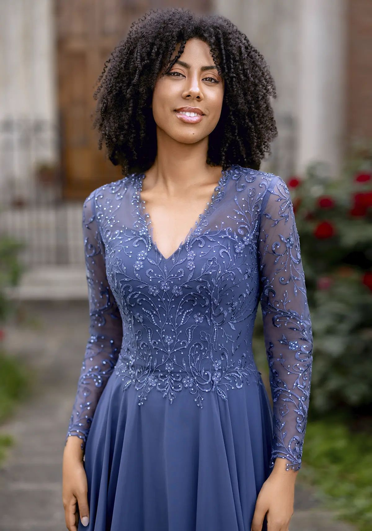 Frau in einem Chiffon-Abendkleid mit langen Ärmeln und hinten hoch geschossen in der Farbe rauchblau, Close-up