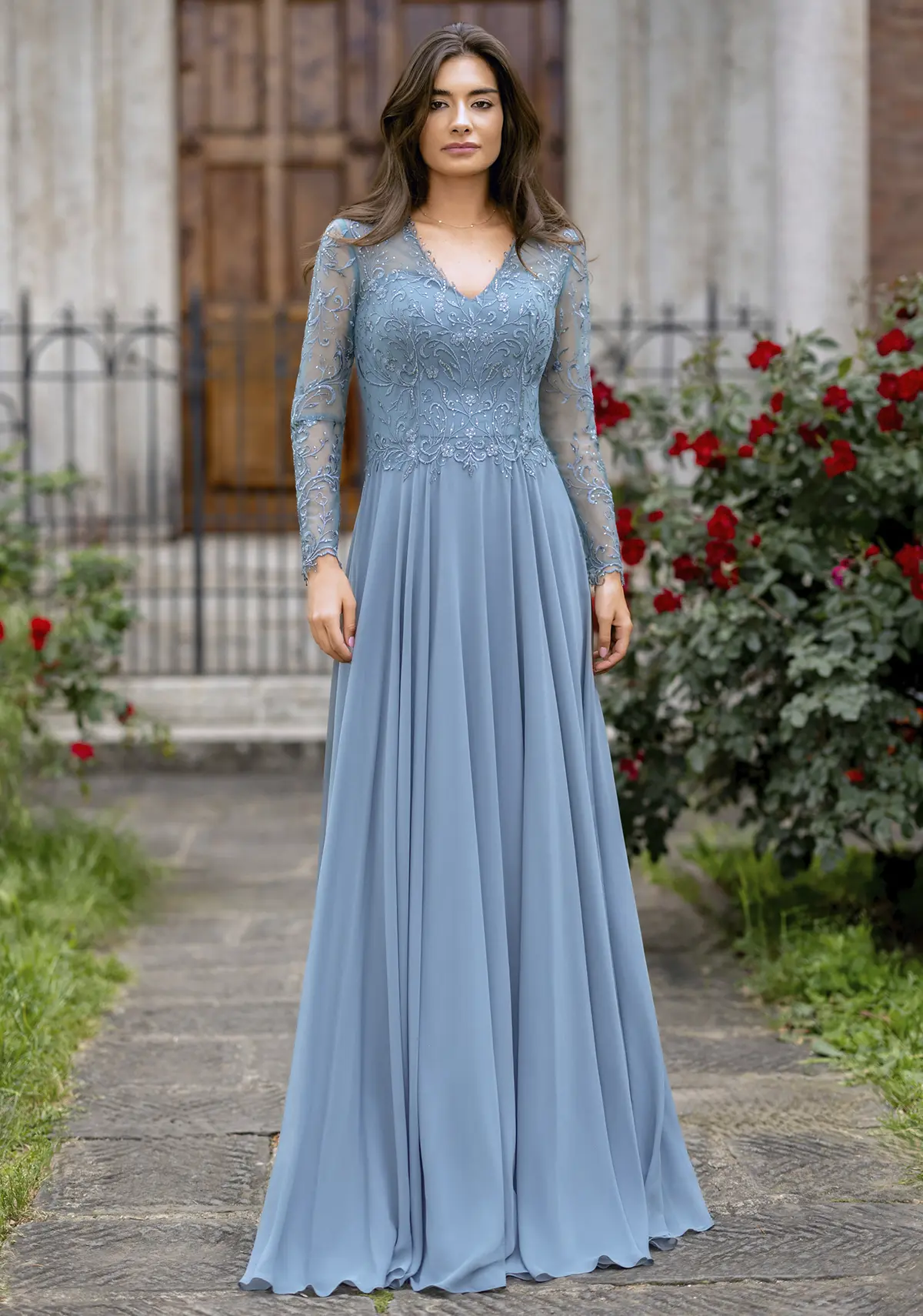 Frau in einem Chiffon-Abendkleid mit langen Ärmeln und hinten hoch geschossen in der Farbe hellblau