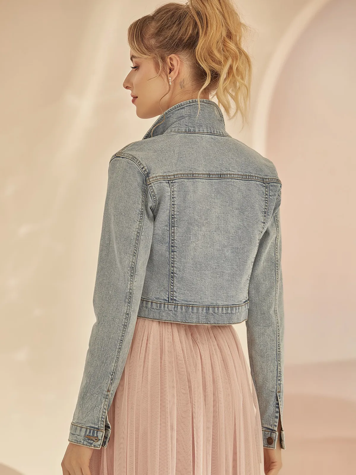 Braut in einer kurzen Jeans-Jacke mit langen Ärmeln, Rückenansicht